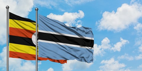 Uganda and Botswana flag waving in the wind against white cloudy blue sky together. Diplomacy concept, international relations.