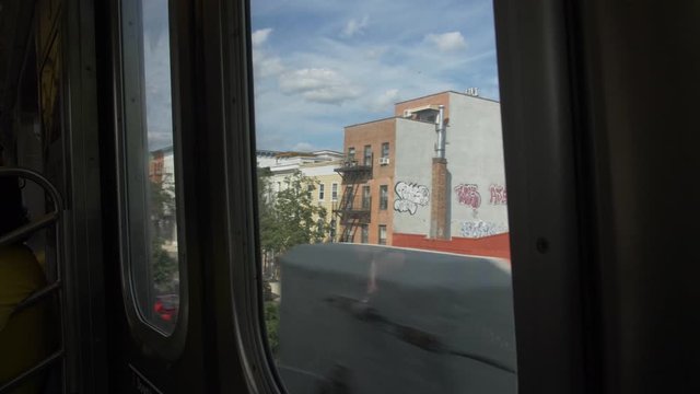 handheld shot of brooklyn streets through subways windows