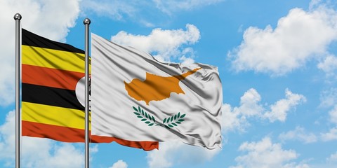Uganda and Cyprus flag waving in the wind against white cloudy blue sky together. Diplomacy...