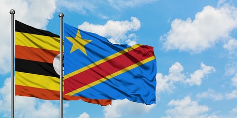Uganda and Congo flag waving in the wind against white cloudy blue sky together. Diplomacy concept, international relations.