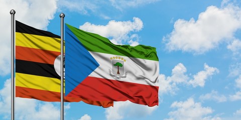 Uganda and Equatorial Guinea flag waving in the wind against white cloudy blue sky together. Diplomacy concept, international relations.