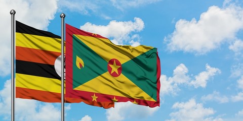 Uganda and Grenada flag waving in the wind against white cloudy blue sky together. Diplomacy concept, international relations.