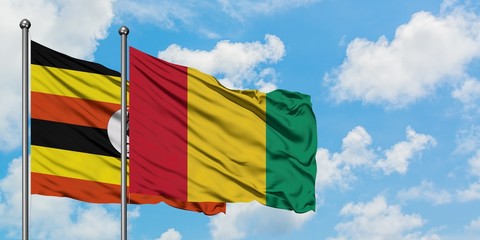 Uganda and Guinea flag waving in the wind against white cloudy blue sky together. Diplomacy concept, international relations.