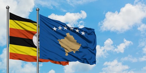 Uganda and Kosovo flag waving in the wind against white cloudy blue sky together. Diplomacy concept, international relations.