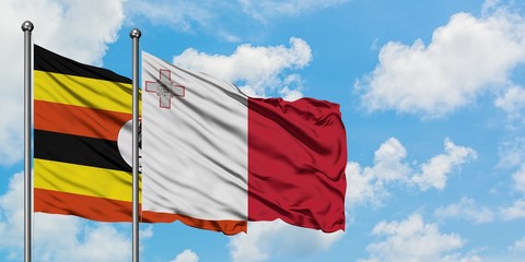 Uganda and Malta flag waving in the wind against white cloudy blue sky together. Diplomacy concept, international relations.
