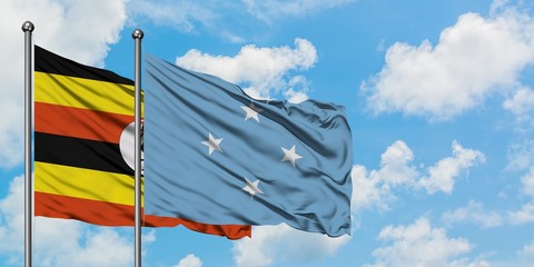 Uganda and Micronesia flag waving in the wind against white cloudy blue sky together. Diplomacy concept, international relations.