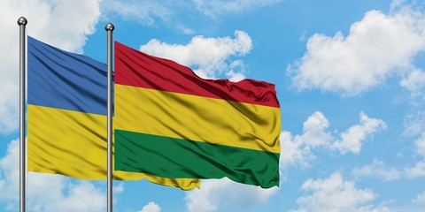 Ukraine and Bolivia flag waving in the wind against white cloudy blue sky together. Diplomacy concept, international relations.