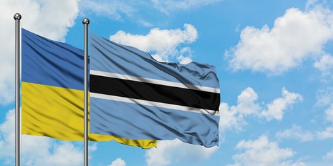 Ukraine and Botswana flag waving in the wind against white cloudy blue sky together. Diplomacy concept, international relations.