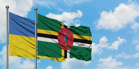Ukraine and Dominica flag waving in the wind against white cloudy blue sky together. Diplomacy concept, international relations.