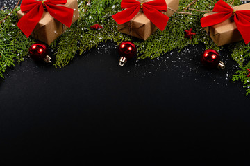 Christmas composition. Girlanda with Christmas ornaments and gifts on black background and blank notepad. Christmas, winter, new year concept. Flat lay, top view, copy space. © Julio Ricco