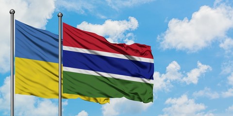 Ukraine and Gambia flag waving in the wind against white cloudy blue sky together. Diplomacy concept, international relations.