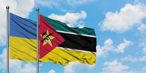 Ukraine and Mozambique flag waving in the wind against white cloudy blue sky together. Diplomacy concept, international relations.