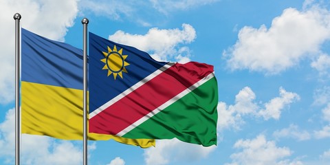 Ukraine and Namibia flag waving in the wind against white cloudy blue sky together. Diplomacy concept, international relations.