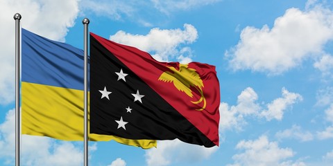 Ukraine and Papua New Guinea flag waving in the wind against white cloudy blue sky together. Diplomacy concept, international relations.