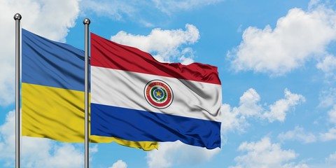 Ukraine and Paraguay flag waving in the wind against white cloudy blue sky together. Diplomacy concept, international relations.