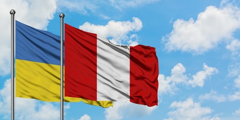 Ukraine and Peru flag waving in the wind against white cloudy blue sky together. Diplomacy concept, international relations.