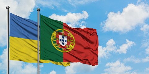 Ukraine and Portugal flag waving in the wind against white cloudy blue sky together. Diplomacy concept, international relations.