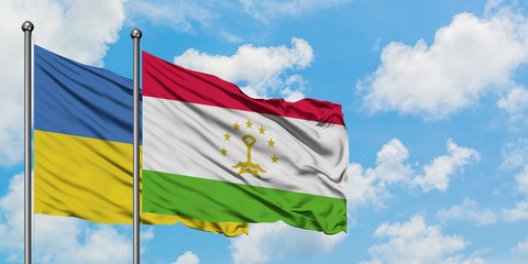 Ukraine and Tajikistan flag waving in the wind against white cloudy blue sky together. Diplomacy concept, international relations.