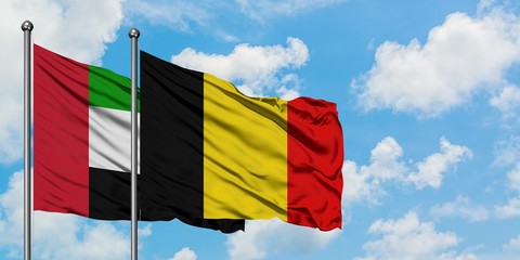 United Arab Emirates and Belgium flag waving in the wind against white cloudy blue sky together. Diplomacy concept, international relations.