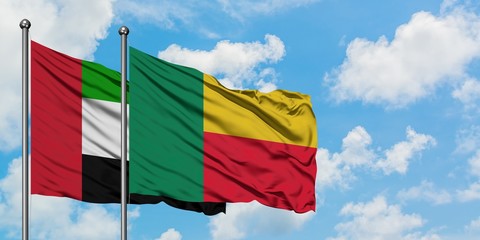 United Arab Emirates and Benin flag waving in the wind against white cloudy blue sky together. Diplomacy concept, international relations.