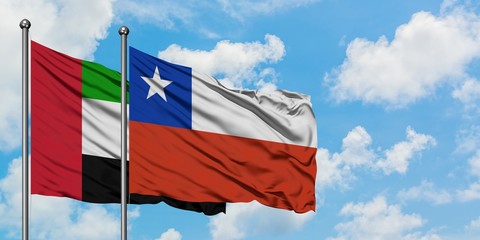 United Arab Emirates and Chile flag waving in the wind against white cloudy blue sky together. Diplomacy concept, international relations.