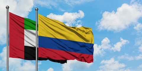 United Arab Emirates and Colombia flag waving in the wind against white cloudy blue sky together. Diplomacy concept, international relations.