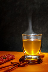 Hot clear Japanese tea in a glass elegant with chopsticks