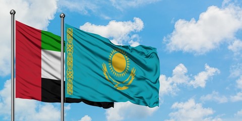United Arab Emirates and Kazakhstan flag waving in the wind against white cloudy blue sky together. Diplomacy concept, international relations.