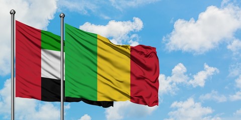 United Arab Emirates and Mali flag waving in the wind against white cloudy blue sky together. Diplomacy concept, international relations.