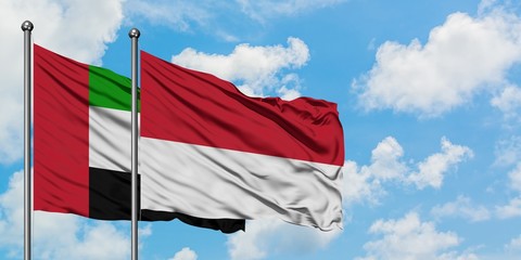 United Arab Emirates and Monaco flag waving in the wind against white cloudy blue sky together. Diplomacy concept, international relations.
