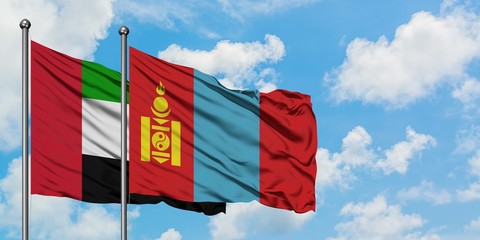 United Arab Emirates and Mongolia flag waving in the wind against white cloudy blue sky together. Diplomacy concept, international relations.