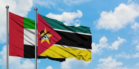 United Arab Emirates and Mozambique flag waving in the wind against white cloudy blue sky together. Diplomacy concept, international relations.