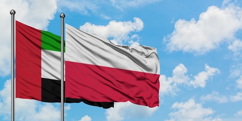 United Arab Emirates and Poland flag waving in the wind against white cloudy blue sky together. Diplomacy concept, international relations.