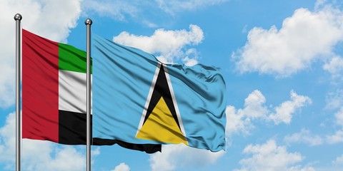 United Arab Emirates and Saint Lucia flag waving in the wind against white cloudy blue sky together. Diplomacy concept, international relations.