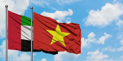 United Arab Emirates and Vietnam flag waving in the wind against white cloudy blue sky together. Diplomacy concept, international relations.