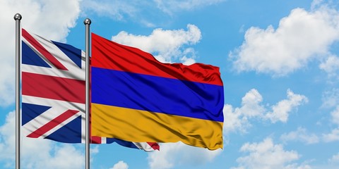 United Kingdom and Armenia flag waving in the wind against white cloudy blue sky together. Diplomacy concept, international relations.