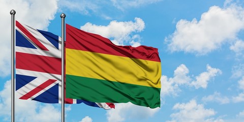 United Kingdom and Bolivia flag waving in the wind against white cloudy blue sky together. Diplomacy concept, international relations.
