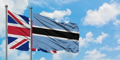 United Kingdom and Botswana flag waving in the wind against white cloudy blue sky together. Diplomacy concept, international relations.