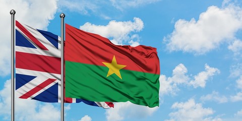 United Kingdom and Burkina Faso flag waving in the wind against white cloudy blue sky together. Diplomacy concept, international relations.