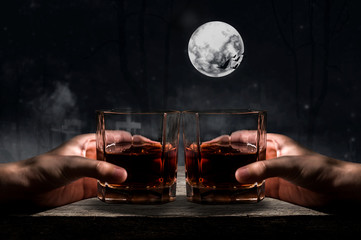 whiskey glass on wooden bar and halloween background.