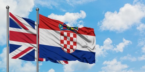 United Kingdom and Croatia flag waving in the wind against white cloudy blue sky together. Diplomacy concept, international relations.