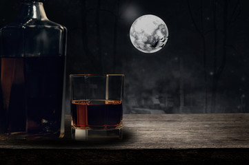 whiskey glass on wooden bar and halloween background.
