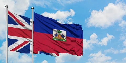 United Kingdom and Haiti flag waving in the wind against white cloudy blue sky together. Diplomacy concept, international relations.