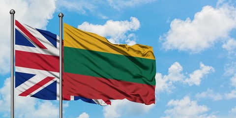United Kingdom and Lithuania flag waving in the wind against white cloudy blue sky together. Diplomacy concept, international relations.