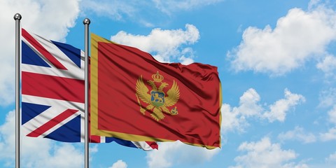 United Kingdom and Montenegro flag waving in the wind against white cloudy blue sky together. Diplomacy concept, international relations.