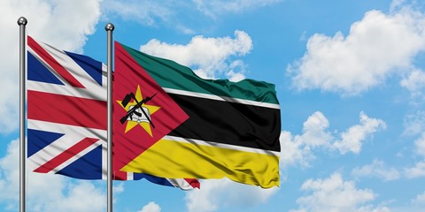 United Kingdom and Mozambique flag waving in the wind against white cloudy blue sky together. Diplomacy concept, international relations.
