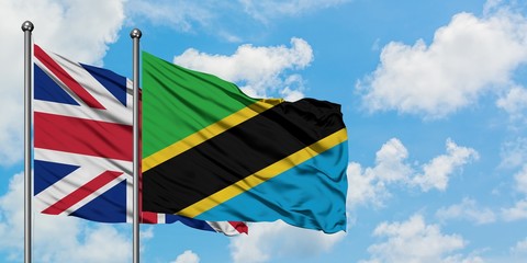 United Kingdom and Tanzania flag waving in the wind against white cloudy blue sky together. Diplomacy concept, international relations.