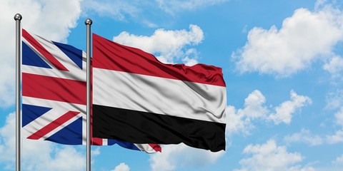 United Kingdom and Yemen flag waving in the wind against white cloudy blue sky together. Diplomacy concept, international relations.