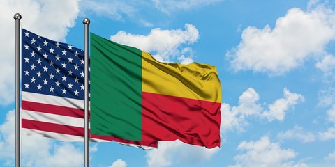 United States and Benin flag waving in the wind against white cloudy blue sky together. Diplomacy...