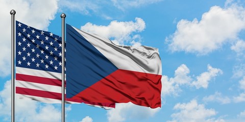 United States and Czech Republic flag waving in the wind against white cloudy blue sky together. Diplomacy concept, international relations.